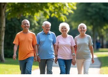 A diverse group of cheerful seniors walking together on a path in a lush green park in Singapore, enjoying companionship.
