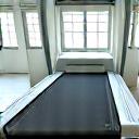 Person safely using a treadmill in a clean gym environment.